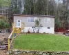 home featuring stairway, a view of trees, and a front yard home featuring stairway, a view of trees, and a front yard