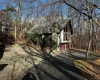 View of side of property with a chimney, driveway, a shingled roof, and a garage View of side of property with a chimney, driveway, a shingled roof, and a garage