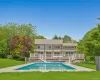 Rear view of house with stairs, a wooden deck, and an outdoor pool Rear view of house with stairs, a wooden deck, and an outdoor pool