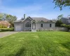 Single story home featuring concrete driveway, a chimney, a shingled roof, and a garage Single story home featuring concrete driveway, a chimney, a shingled roof, and a garage