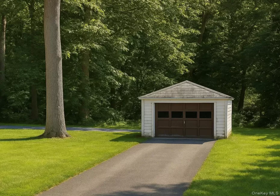 Detached garage with aphalt driveway and a wooded view Detached garage with aphalt driveway and a wooded view