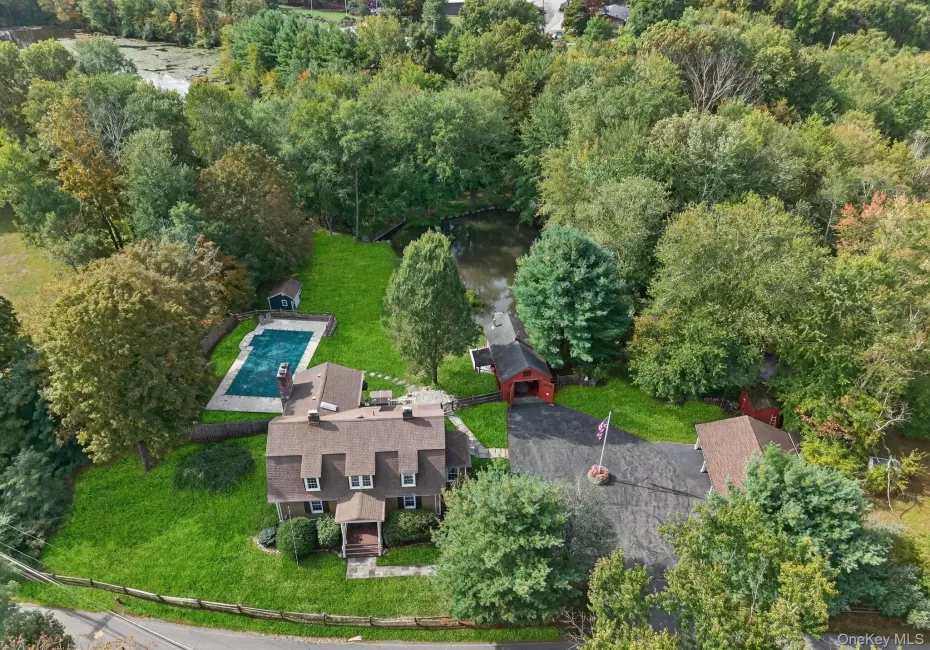 Aerial view of property's location with a pool area and beautiful private pond Aerial view of property's location with a pool area and beautiful private pond