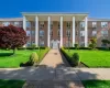 Brick building facade featuring a portico with white columns Brick building facade featuring a portico with white columns