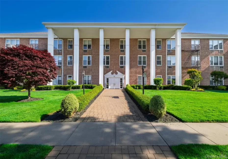 Brick building facade featuring a portico with white columns Brick building facade featuring a portico with white columns
