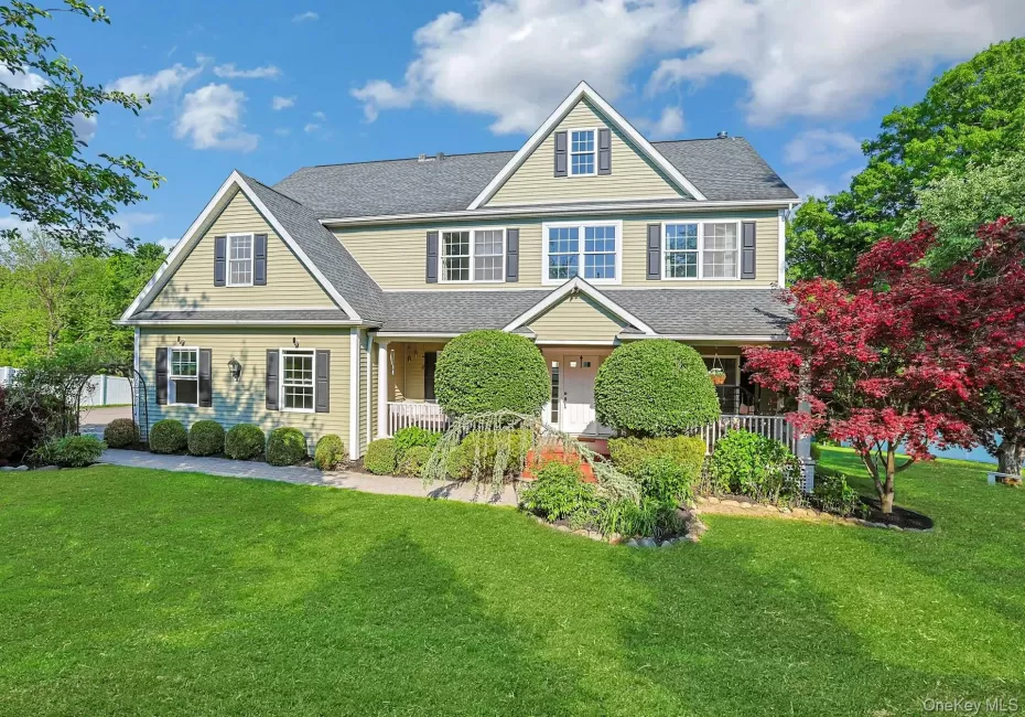 Stunning front porch colonial showcasing exceptional curb appeal, with a lush manicured lawn, mature specimen plantings, and a charming facade. Stunning front porch colonial showcasing exceptional curb appeal, with a lush manicured lawn, mature specimen plantings, and a charming facade.