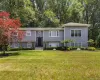 Raised ranch with a front yard and view of scattered trees Raised ranch with a front yard and view of scattered trees