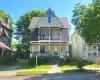 Colonial home.with covered porch, a balcony, and a shingled roof Colonial home.with covered porch, a balcony, and a shingled roof