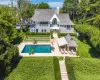Back of property with a patio area, a balcony, a lawn, a chimney, and an outdoor pool Back of property with a patio area, a balcony, a lawn, a chimney, and an outdoor pool