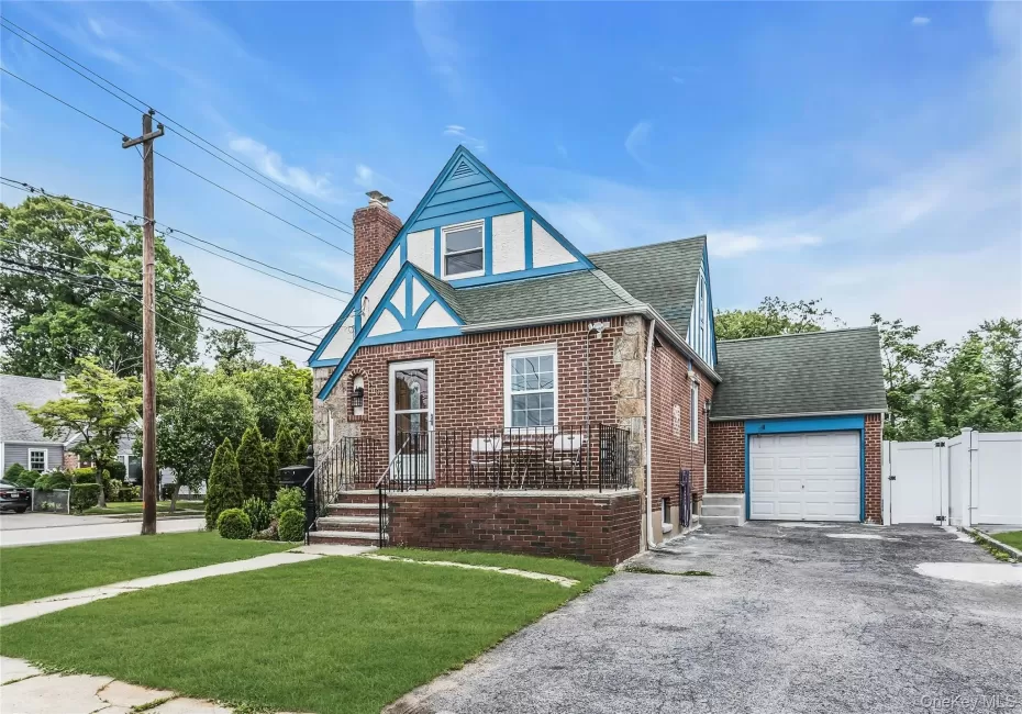 Brick and stone facade residence featuring a front lawn and paved driveway Brick and stone facade residence featuring a front lawn and paved driveway