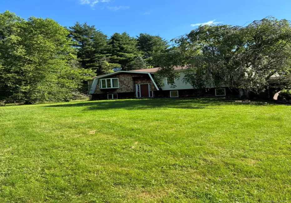 View of front of house with a gambrel roof and a front yard View of front of house with a gambrel roof and a front yard