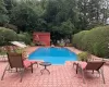 View of pool with a storage unit and a patio area View of pool with a storage unit and a patio area