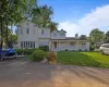 View of front facade featuring a porch, a front lawn, and a chimney View of front facade featuring a porch, a front lawn, and a chimney
