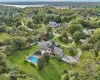 A captivating aerial perspective showcasing the property’s rear elevation, where architecture and landscape blend in perfect harmony. Virtually Staged to show open pool. A captivating aerial perspective showcasing the property’s rear elevation, where architecture and landscape blend in perfect harmony. Virtually Staged to show open pool.