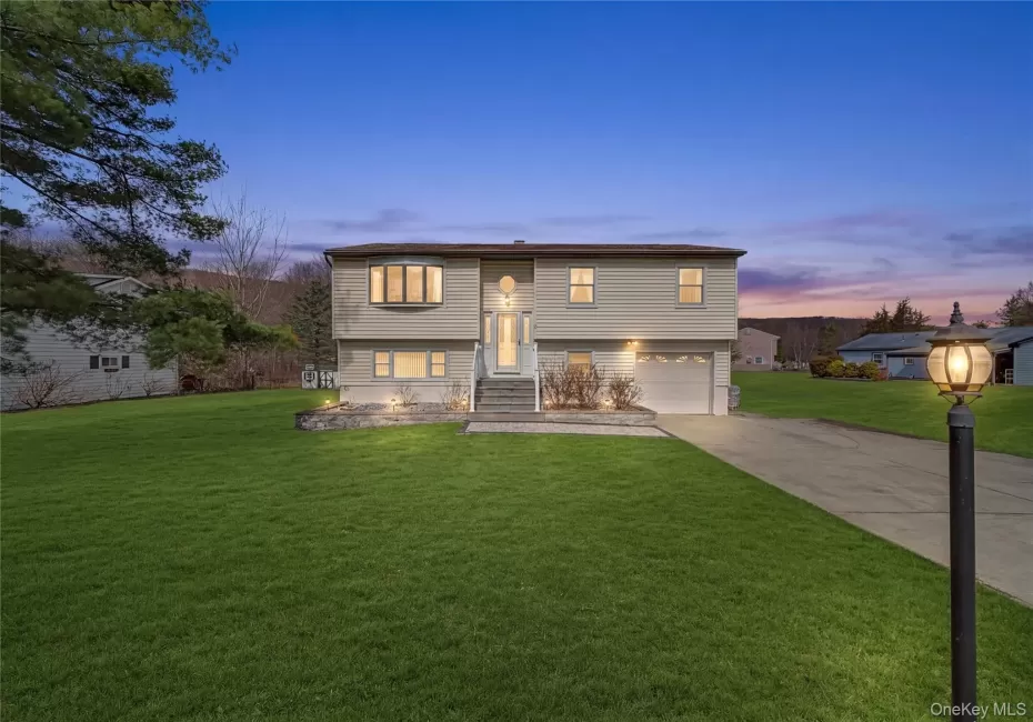 Raised ranch with a lawn, driveway, and an attached garage Raised ranch with a lawn, driveway, and an attached garage