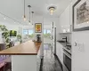 Modern kitchen featuring white high-gloss cabinetry, a black sink, and stainless steel appliances Modern kitchen featuring white high-gloss cabinetry, a black sink, and stainless steel appliances