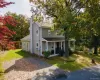 View of front facade with a front yard, covered porch, and a chimney View of front facade with a front yard, covered porch, and a chimney