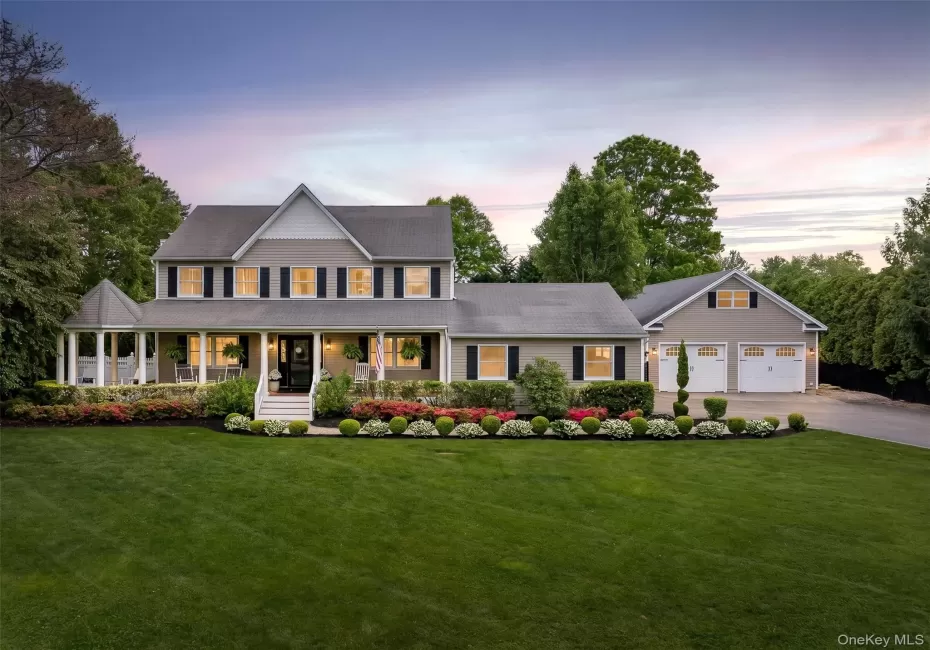 Traditional-style residence featuring a prominent front porch with a rounded gazebo extension, a dormered roofline, and an attached two-car garage Traditional-style residence featuring a prominent front porch with a rounded gazebo extension, a dormered roofline, and an attached two-car garage