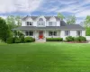 Stunning curb appeal featuring a classic white exterior, a prominent red front door, a covered porch, and beautiful dormer accents." Stunning curb appeal featuring a classic white exterior, a prominent red front door, a covered porch, and beautiful dormer accents."