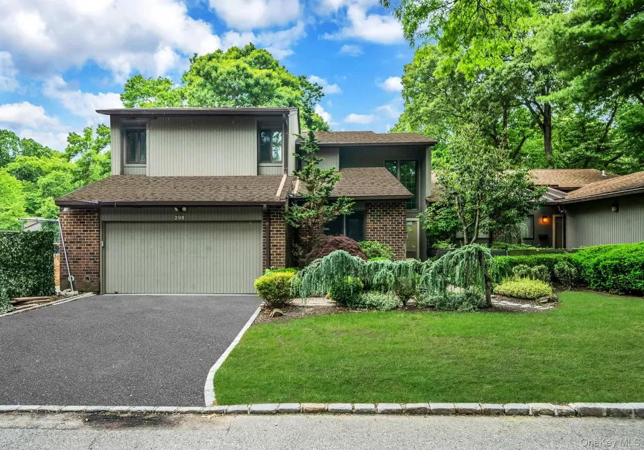 Contemporary residence featuring a two-car garage with an asphalt driveway Contemporary residence featuring a two-car garage with an asphalt driveway