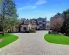 View of front of home featuring a front yard, stucco siding, curved driveway, and a chimney View of front of home featuring a front yard, stucco siding, curved driveway, and a chimney
