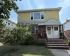View of front facade featuring brick siding, a high end roof, and a front yard View of front facade featuring brick siding, a high end roof, and a front yard