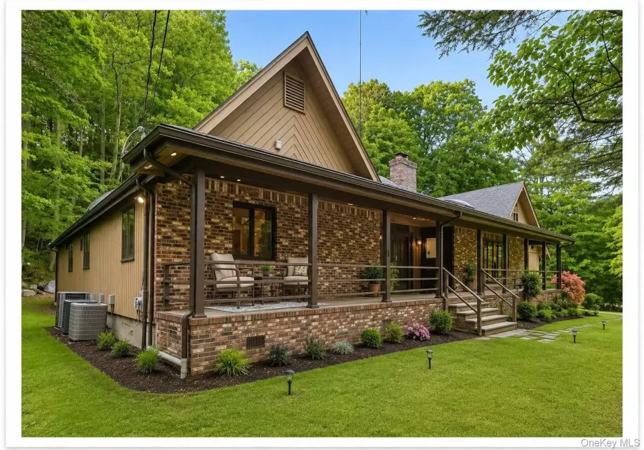 Brick and siding exterior with a covered front porch featuring multiple seating areas Brick and siding exterior with a covered front porch featuring multiple seating areas