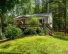 View of front facade featuring a deck and a front lawn View of front facade featuring a deck and a front lawn