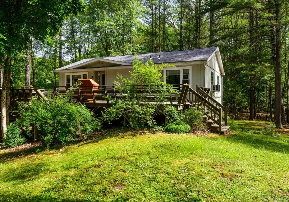 View of front facade featuring a deck and a front lawn View of front facade featuring a deck and a front lawn