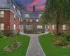 View of front facade with a high end roof, brick siding, and a lawn View of front facade with a high end roof, brick siding, and a lawn