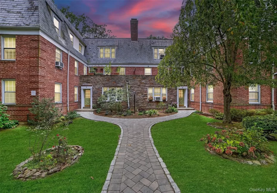 View of front facade with a high end roof, brick siding, and a lawn View of front facade with a high end roof, brick siding, and a lawn