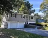 Bi-level home with a chimney, driveway, and an attached garage Bi-level home with a chimney, driveway, and an attached garage