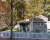 Single-story residence featuring light gray siding and a white picket fence Single-story residence featuring light gray siding and a white picket fence