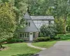 Tudor style carriage house with stone siding, a front lawn, and stucco siding Tudor style carriage house with stone siding, a front lawn, and stucco siding
