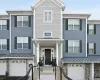 Townhome exterior featuring varied siding materials, stone accents, and a covered entry porch Townhome exterior featuring varied siding materials, stone accents, and a covered entry porch
