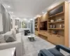 Living room featuring custom built-in wood cabinetry and shelving, recessed lighting, expansive windows with custom automated treatments, leading to one of two balconies. Living room featuring custom built-in wood cabinetry and shelving, recessed lighting, expansive windows with custom automated treatments, leading to one of two balconies.