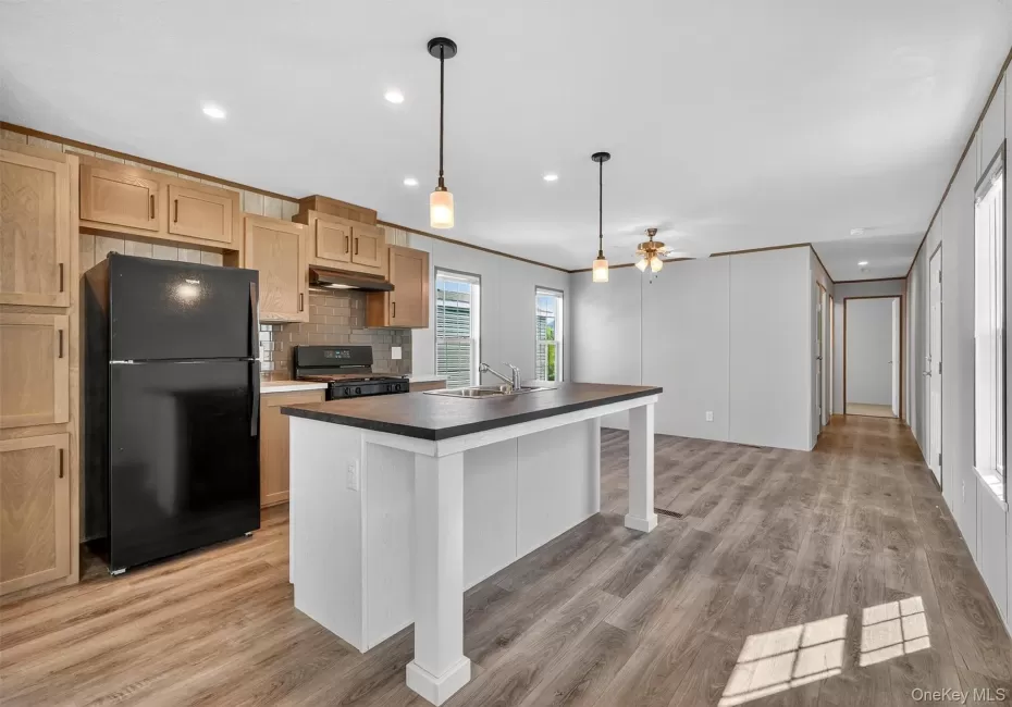Kitchen with black appliances, a kitchen island with sink, decorative backsplash, recessed lighting, and ornamental molding Kitchen with black appliances, a kitchen island with sink, decorative backsplash, recessed lighting, and ornamental molding
