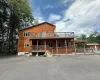 Wood-sided residence featuring a multi-level deck, ground-level patio, and an outdoor pool Wood-sided residence featuring a multi-level deck, ground-level patio, and an outdoor pool