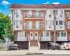 Multi-unit brick building featuring white vinyl siding and multiple balconies with white railings Multi-unit brick building featuring white vinyl siding and multiple balconies with white railings