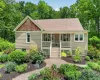 Bungalow-style home featuring light tan siding, a front porch, and a shingled roof Bungalow-style home featuring light tan siding, a front porch, and a shingled roof