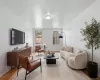 Living area featuring wood-finish flooring, two large windows, a ceiling-mounted light fixture, and white wall finishes Living area featuring wood-finish flooring, two large windows, a ceiling-mounted light fixture, and white wall finishes