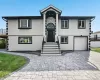 View of front of home with stucco siding, decorative driveway, and an attached garage View of front of home with stucco siding, decorative driveway, and an attached garage