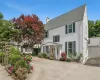 White stucco exterior with a prominent gabled roofline and dark green window shutters White stucco exterior with a prominent gabled roofline and dark green window shutters