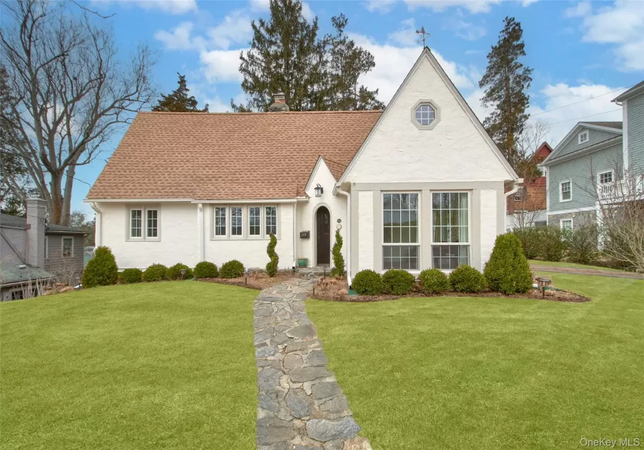 View of front facade with a chimney, a shingled roof, and a front lawn View of front facade with a chimney, a shingled roof, and a front lawn