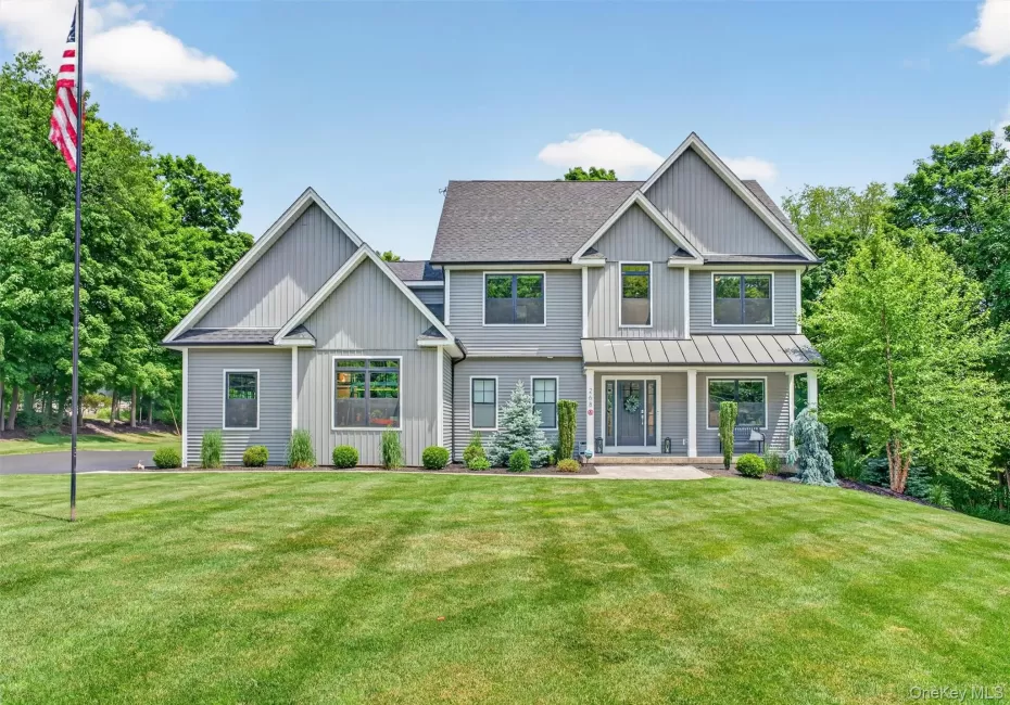 Contemporary gray siding exterior with multiple gables and a covered front porch featuring white columns Contemporary gray siding exterior with multiple gables and a covered front porch featuring white columns