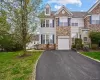 Multi-level townhome featuring stone and siding facade, an integrated garage, and a paved driveway Multi-level townhome featuring stone and siding facade, an integrated garage, and a paved driveway