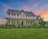 Two-story residence featuring light gray siding, dark roof shingles, and red window shutters Two-story residence featuring light gray siding, dark roof shingles, and red window shutters