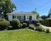 White siding exterior with black window shutters and a gabled roof White siding exterior with black window shutters and a gabled roof