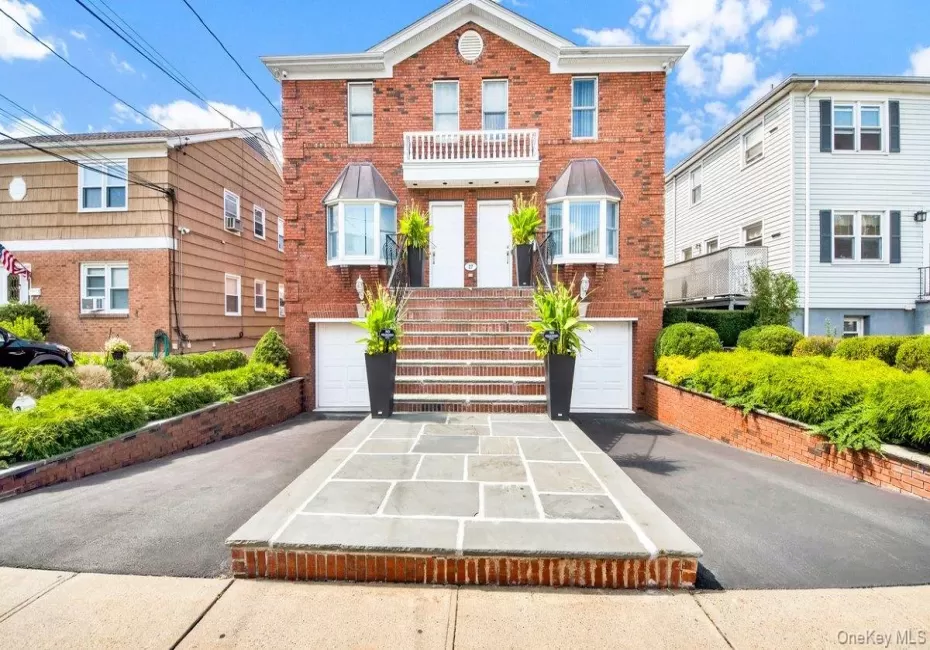 Brick Multi Family home featuring a symmetrical design, dual entry doors, and a stone-paved walkway Brick Multi Family home featuring a symmetrical design, dual entry doors, and a stone-paved walkway