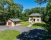 Stone-clad residence featuring a central arched entryway, multi-paned windows, and a dark shingle roof Stone-clad residence featuring a central arched entryway, multi-paned windows, and a dark shingle roof
