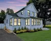 View of front facade featuring driveway, a front yard, and board and batten siding View of front facade featuring driveway, a front yard, and board and batten siding